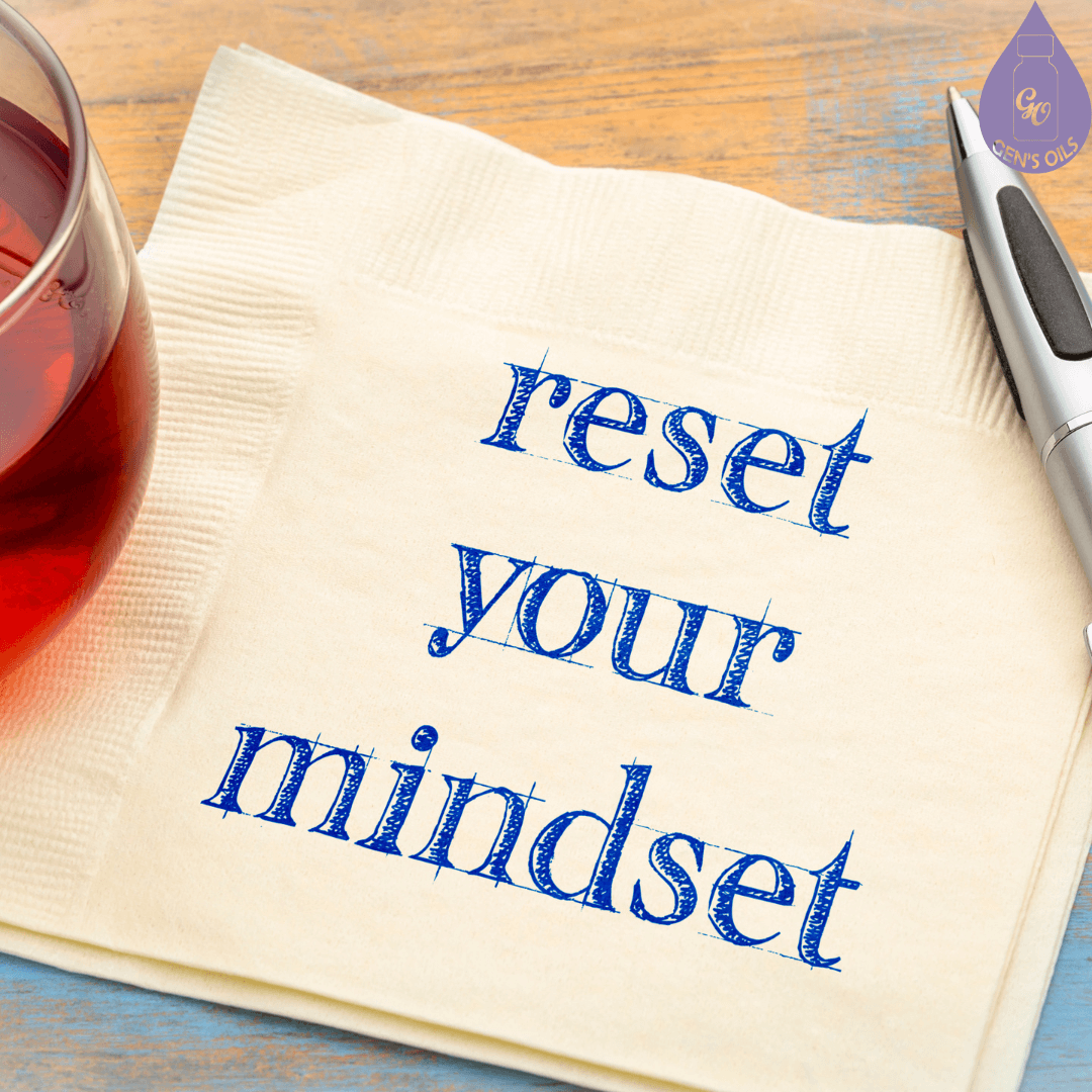 A piece of paper with the words "reset your mindset", with a pen & glass of tea.