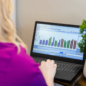 Deanna Thomas analysing client bioresonance health scan data on a laptop at Middlesbrough acupuncture clinic.