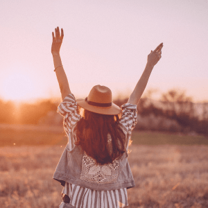 “Woman with arms raised at sunset – acupuncture for menopause helping balance mood swings and emotional wellbeing”