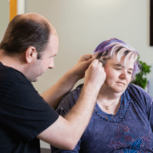 Practitioner gently placing NADA ear acupuncture needles during a one-to-one calming session in a Middlesbrough wellbeing clinic